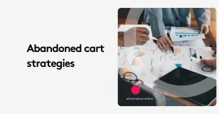 Team discussing abandoned cart strategies with charts and graphs on a table.