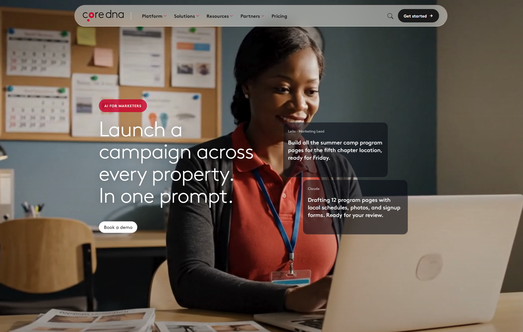 Woman working on a laptop for a marketing campaign with a corkboard in the background.
